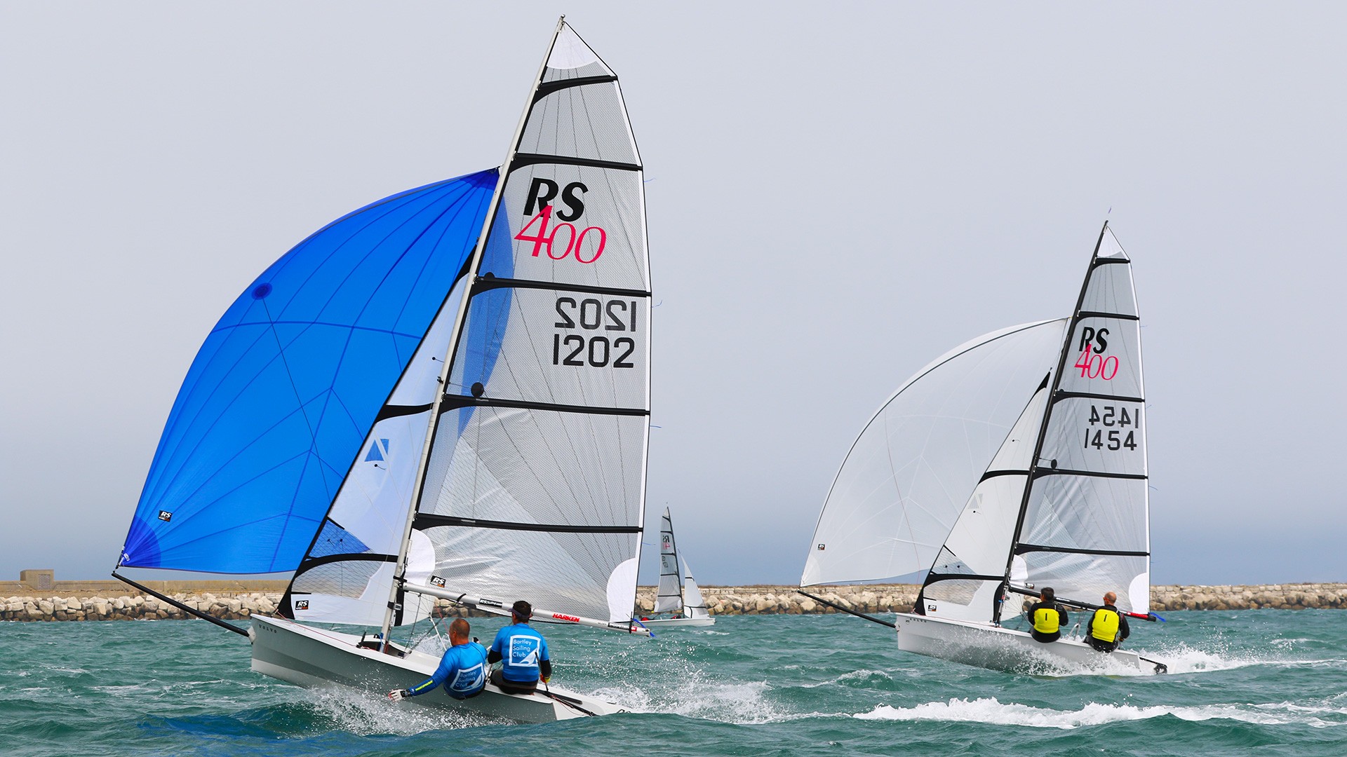 Two RS400 Sailing Dinghy racing downwind with their blue and white asymmetric kites up. Going very fast!